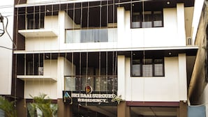Un edificio de varios pisos con un letrero que dice 'Sri SAI Suryanagar Residency'.