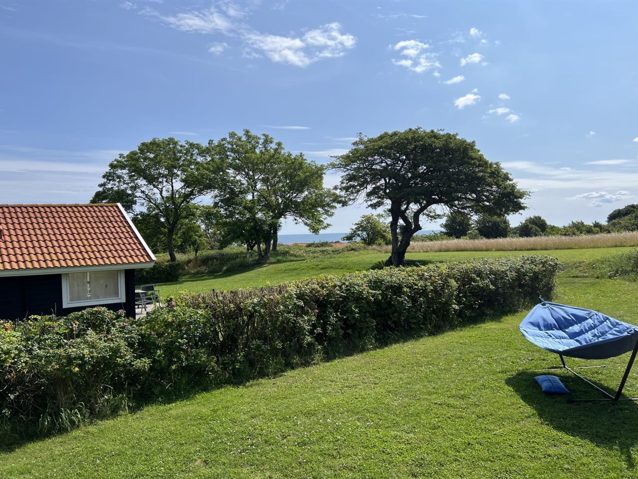 A house with a tiled roof, surrounded by a well-maintained lawn and trees.