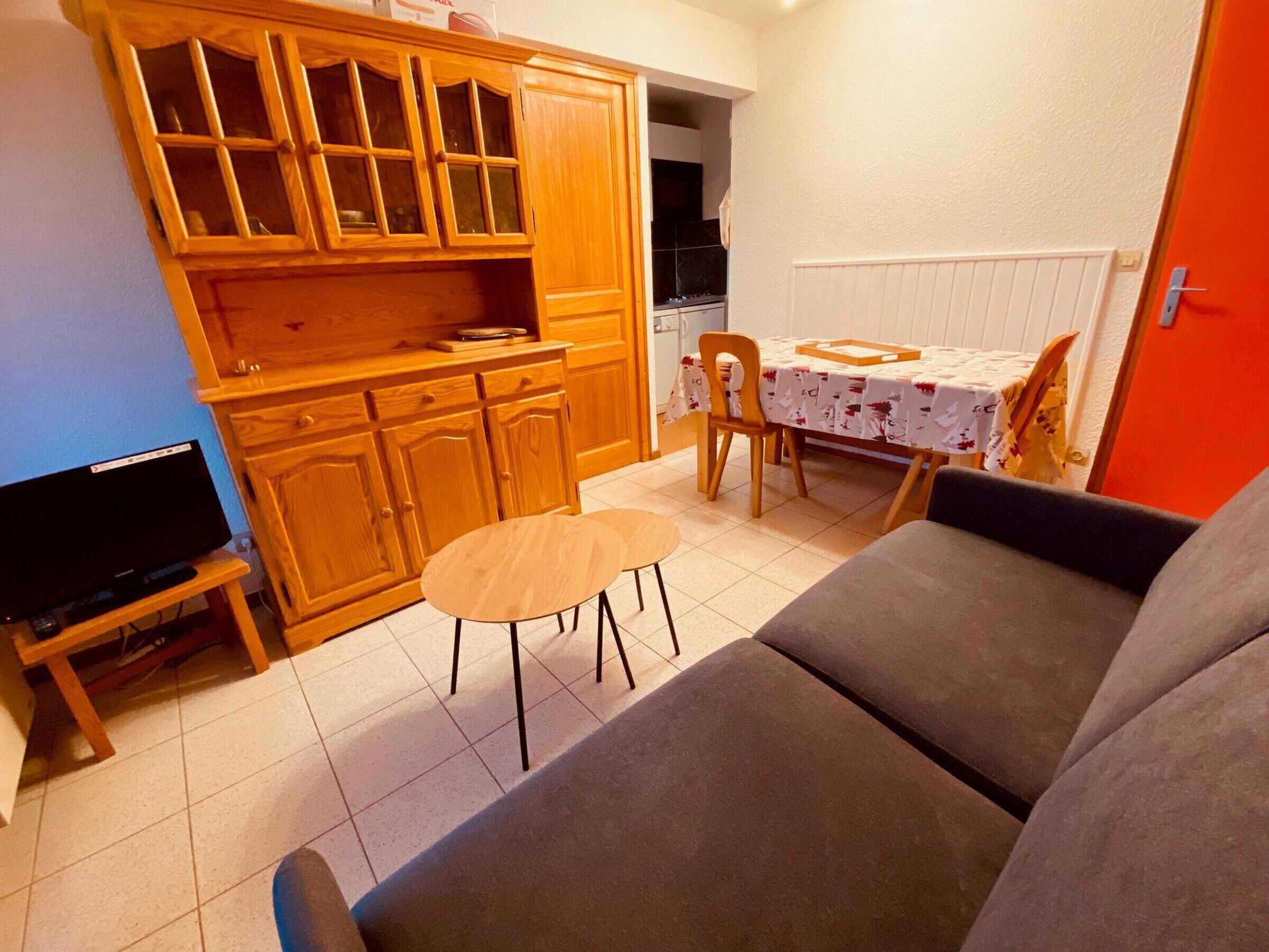 A compact living space with a kitchenette, a dining area, and a seating area.
