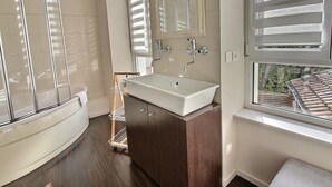 A modern bathroom with a freestanding bathtub, a large vanity with a mirror, and a window with blinds. - Elegant Home in Colmar: Terrace, Hot Tub, Parking, Steps from Historic Center (Colmar)
