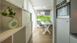 Eine moderne Küche mit Essbereich, einem Einbauofen und Blick ins Freie.