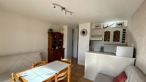 Un espace de vie compact comprenant un coin repas, une kitchenette et un canapé.