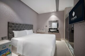 A modern hotel room with a large bed, a vanity with a mirror, and a shower area. - Mari Queen Hotel - Bui Thi Xuan (Ho Chi Minh City)