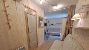 A room with a bed, a desk, a chair, a heater, and a mirror. - Cozy studio 3 ppl, pets ok, parking - Les Deux Alpes (Les Deux Alpes)