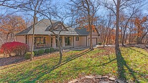 A house with a sloped roof, a front porch, and a well-maintained lawn.