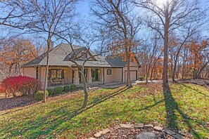 A house with a sloped roof, a front porch, and a well-maintained lawn.