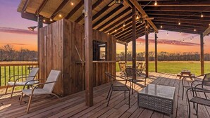 A wooden deck with outdoor furniture and a covered area with string lights.