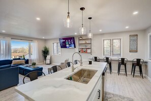 A modern kitchen with a central island, bar stools, and pendant lighting. - Draper Vacation Home - Families & Friends Welcome (Baraboo)