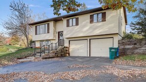 A two-story house with a garage, a front porch, and a stone retaining wall. - Draper Vacation Home - Families & Friends Welcome (Baraboo)