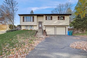A two-story house with a front porch, a garage, and a driveway. - Draper Vacation Home - Families & Friends Welcome (Baraboo)