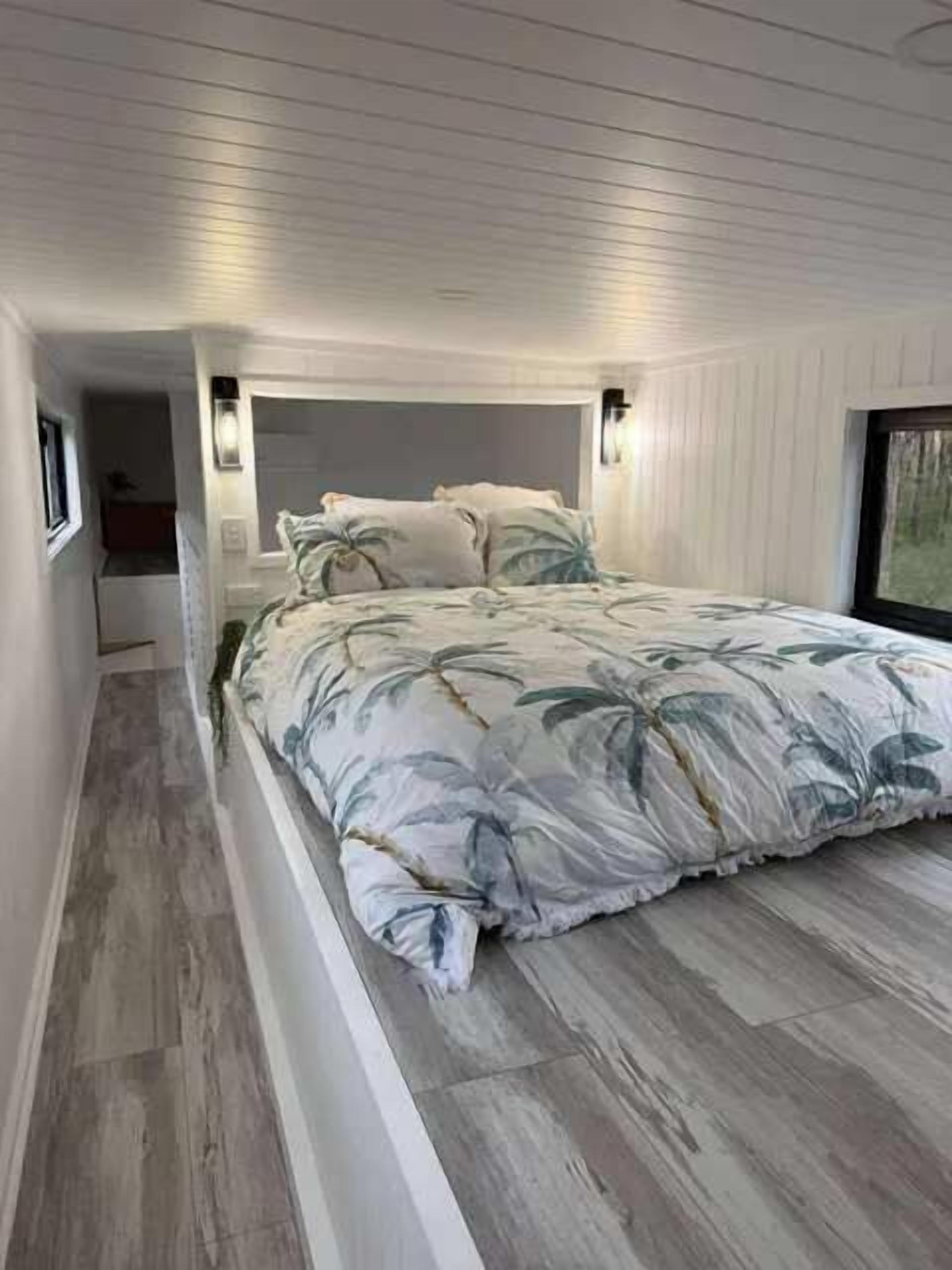 Una camera da letto con un letto, un comodino e una finestra.