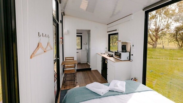 Ein gemütliches Schlafzimmer mit Bett, Schreibtisch und Blick auf eine Rasenfläche.