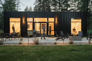 A modern building with large glass windows, outdoor seating, and a well-maintained garden. - Teakettle-Modern-Close To Glacier, Skiing (Columbia Falls)