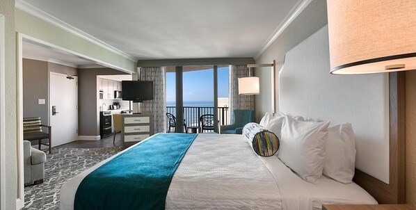 Relax in this inviting room with a large bed, desk, and ocean views from the balcony.