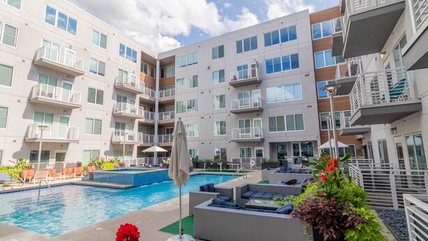 Un hôtel moderne doté d’une piscine, d’un espace extérieur aménagé et de balcons.