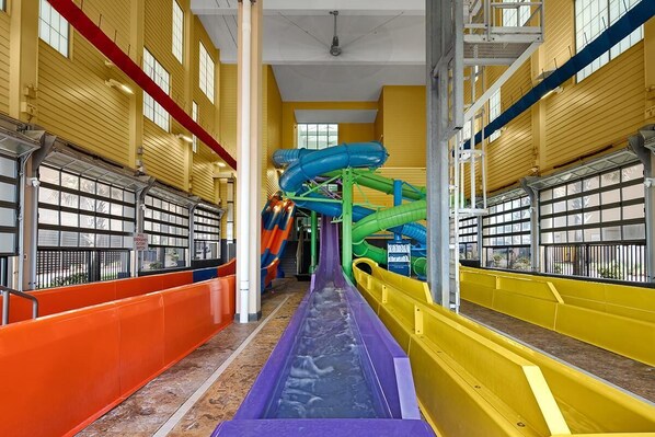 An indoor water park with multiple slides and a central water slide.