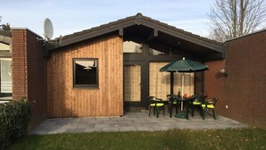 Un patio con una estructura de madera, una antena parabólica y mobiliario exterior.