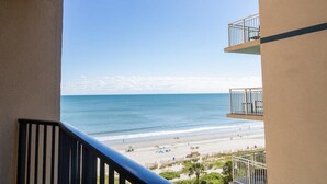 Un balcon avec vue sur une plage et l’océan.