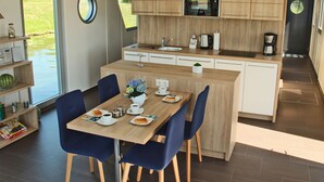 Eine moderne Küche mit Holzausstattung, integriertem Mikrowellenherd und einer Kaffeemaschine.