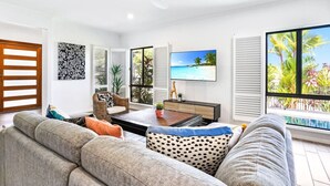 Ein modernes Wohnzimmer mit Sofa, Couchtisch und Fernseher.