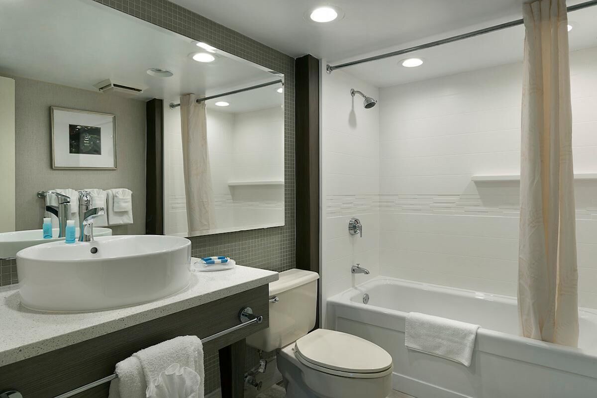Un baño moderno con un lavamanos grande, inodoro y bañera.