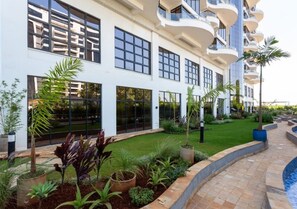 Experience the sleek, contemporary design of this hotel, featuring large windows, a well-manicured lawn, and a pool area.
