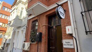 A two-story building with a brick facade, a black door, and a sign indicating it is a guest house. - Beşiktaş Çarşı Pansiyon (Istanbul)