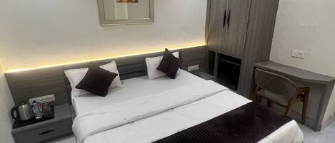 Ein modernes Hotelzimmer mit einem großen Bett, einem Schreibtisch und einem Kleiderschrank.