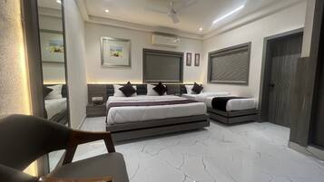 A modern bedroom with a large bed, bedside tables, a ceiling fan, and a large window with blinds.