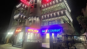 A multi-story building with illuminated signs for a hotel and a bar/restaurant. - Hotel Ankur (Diu)