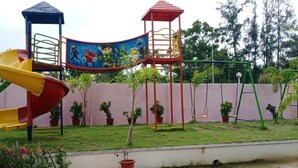 A playground with a slide, climbing structures, and a mural. - Swastik Resort (Kanthi)