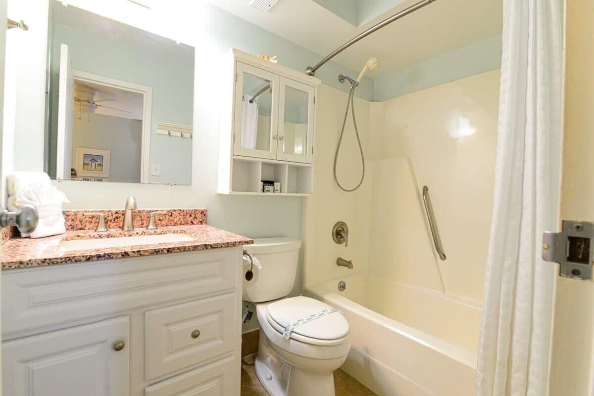 A bathroom with a sink, toilet, and shower.