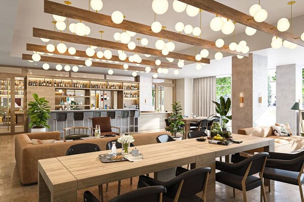 A modern hotel lobby with a long wooden reception desk, a bar area with shelves of bottles, and a dining area with a long table and chairs. - Studio + Views +Rooftop pool |Rainey St (Austin)