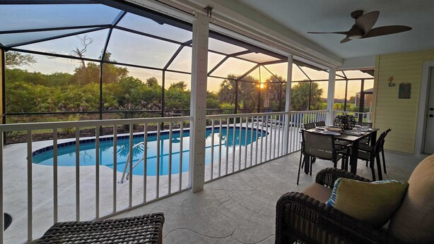 Un patio couvert avec une piscine, du mobilier d’extérieur et un espace repas.