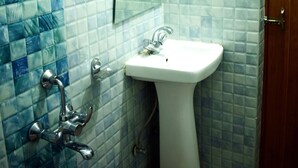 Un baño con lavamanos blanco, un espejo y una ducha.