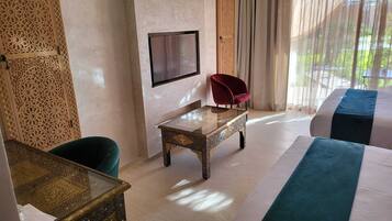 A hotel room with a bed, a small table, a chair, and a TV.