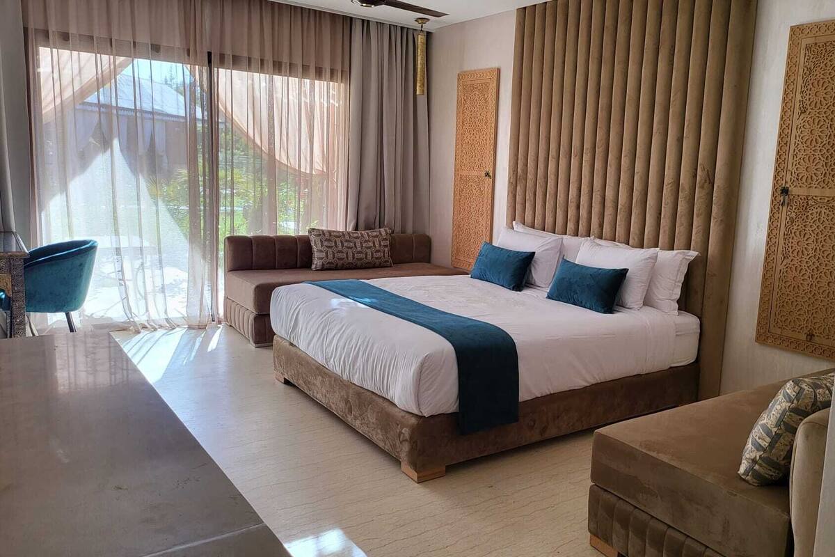Ein geräumiges Schlafzimmer mit einem großen Bett, einer Couch und einem Esstisch.
