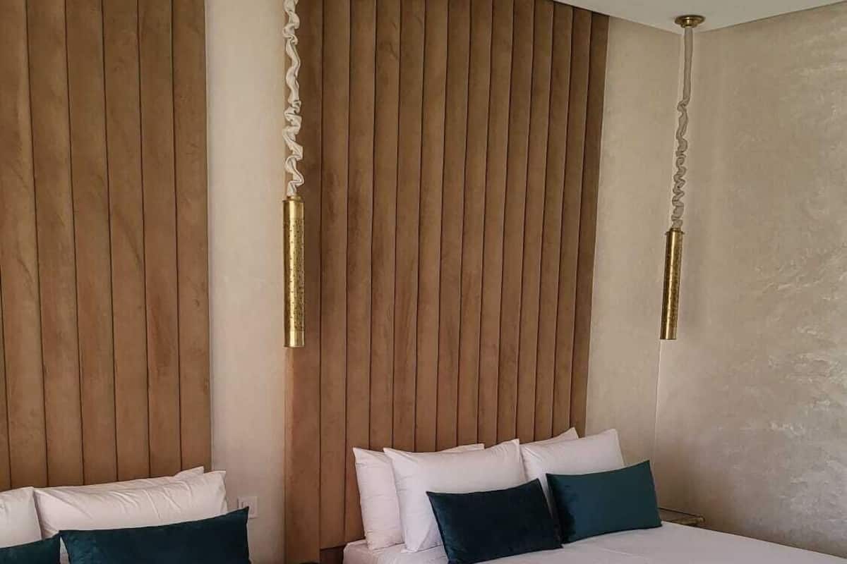 Ein Hotelzimmer mit zwei Betten, Holzwandverkleidung und Deckenventilatoren.
