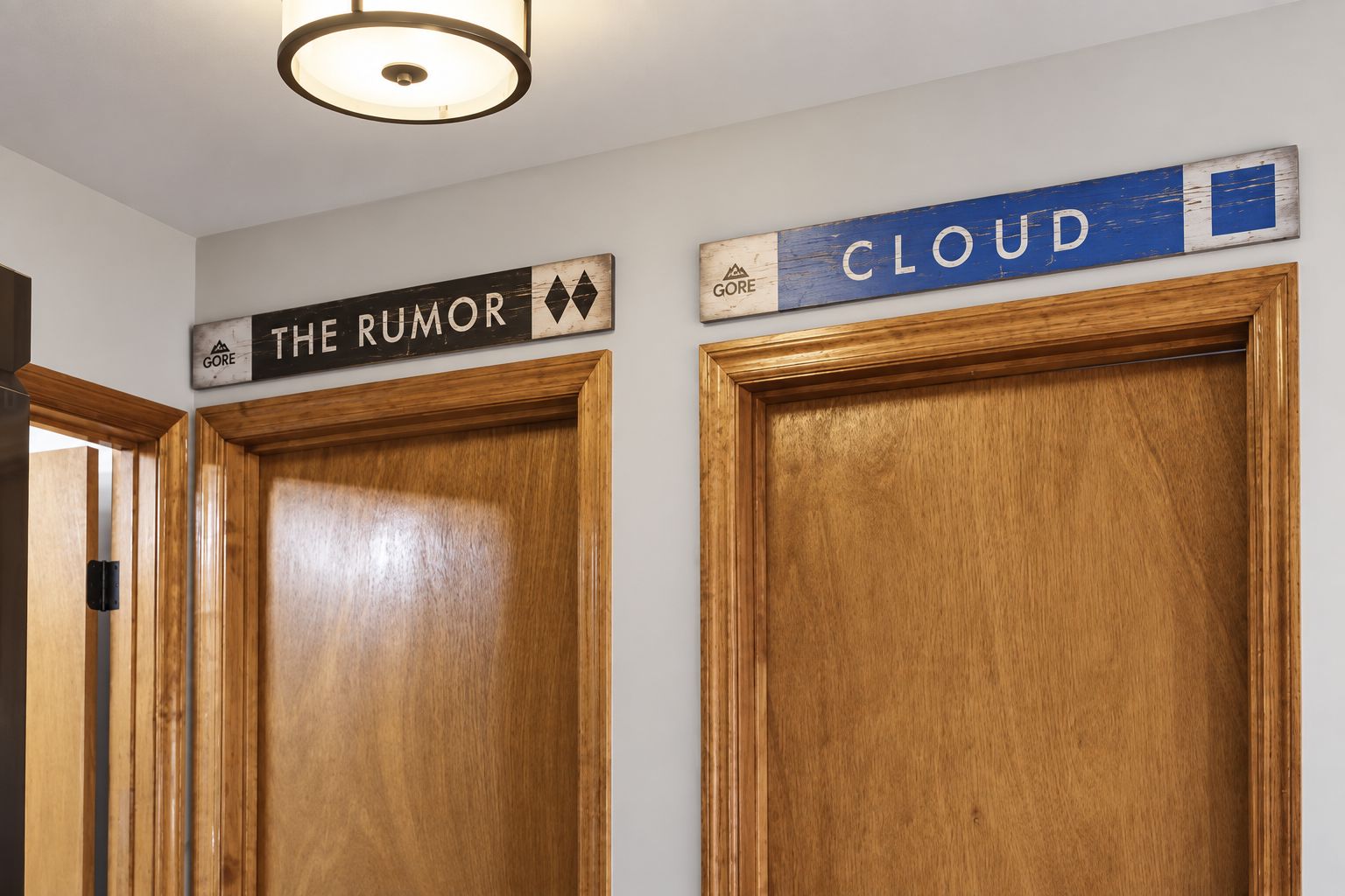 Two wooden doors with signs above them, one labeled 'THE RUMOR' and the other 'CLOUD'.