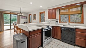 A modern kitchen with wooden cabinets, a stainless steel stove, and a dishwasher.