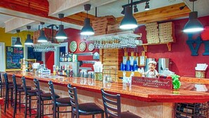 Un'area bar con un bancone in legno, diverse luci a sospensione e un cartello con su scritto 'Remember Stressed'.