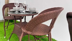 A wicker dining set with a table and chairs, a glass of water, and a bowl on the table. - Lux Suites Gold Park Apartments Kilimani (Nairobi)