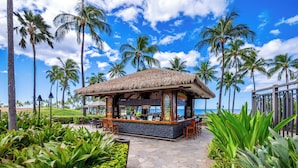 A beachfront bar with a thatched roof, stone pathway, and tropical plants. - Summer Reduced! OT-503 Gorgeous Ocean and Pool View Villa! (Kapolei)