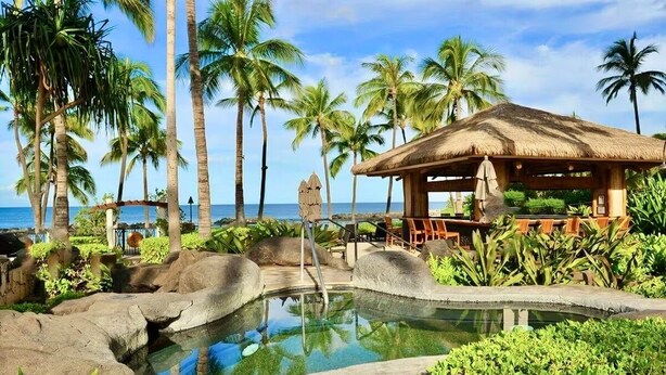 A tropical resort with a pool, palm trees, and a thatched-roof pavilion. - Summer Reduced! OT-503 Gorgeous Ocean and Pool View Villa! (Kapolei)
