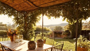 Une terrasse extérieure avec une table, des chaises et des plantes en pot.