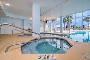 An indoor swimming pool with a 3 ft depth marker, a no diving sign, and a view of palm trees outside. - The Dunes 503 1 Bedroom Condo (Gulf Shores)