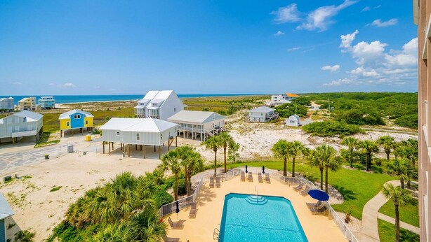 A beachfront property with a swimming pool, multiple beach houses, and a clear view of the ocean. - The Dunes 503 1 Bedroom Condo (Gulf Shores)
