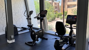 A gym with two stationary bikes, a weight bench, and a treadmill. - Villa Sunrise 1 Bedroom Condo by RedAwning (Scottsdale)