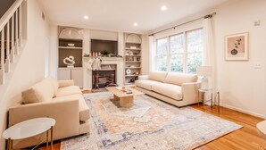 A modern living room with a fireplace, a sofa, a coffee table, and a large window. - Private, Serene Mt Lookout 5B Retreat w/Garage & EV Charger (Cincinnati)