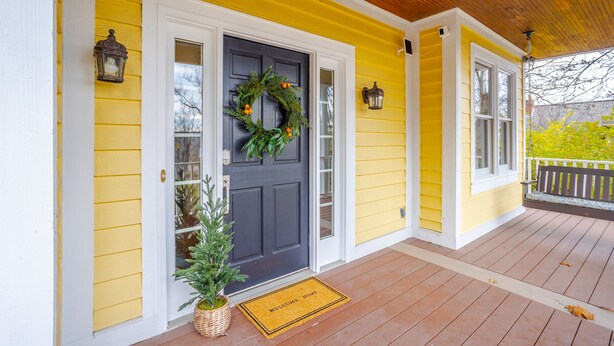 A yellow house with a dark gray door, a wreath, and a small Christmas tree. - Private, Serene Mt Lookout 5B Retreat w/Garage & EV Charger (Cincinnati)